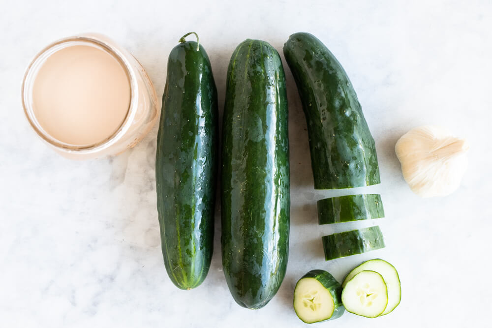 three cucumbers and garlic on kitchen counter
