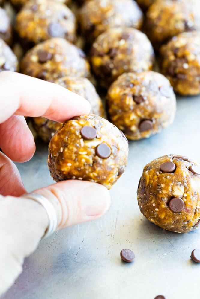 fingers holding a peanut butter pumpkin energy balls