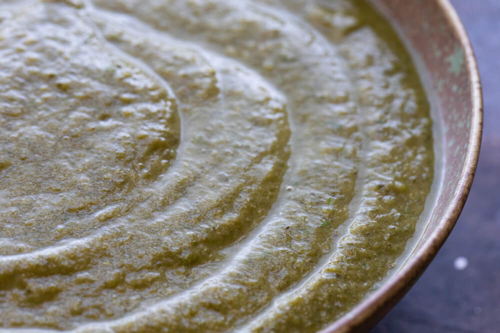 close up of green soup in green bowl