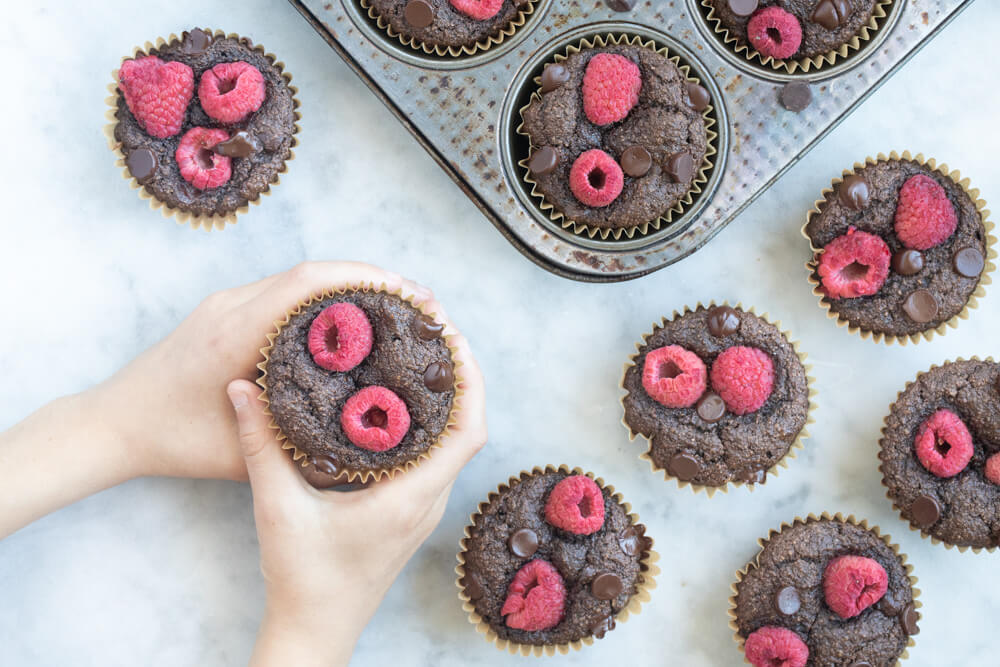 hand holding a vegan and gluten free chocolate raspberry muffin