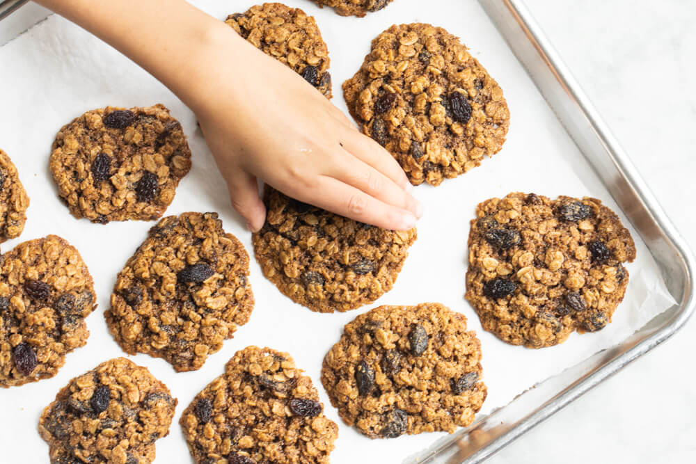 hand reaching for gluten free oatmeal raisin cookie