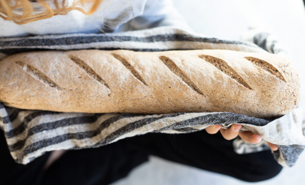 hands holding gluten free seeded sourdough