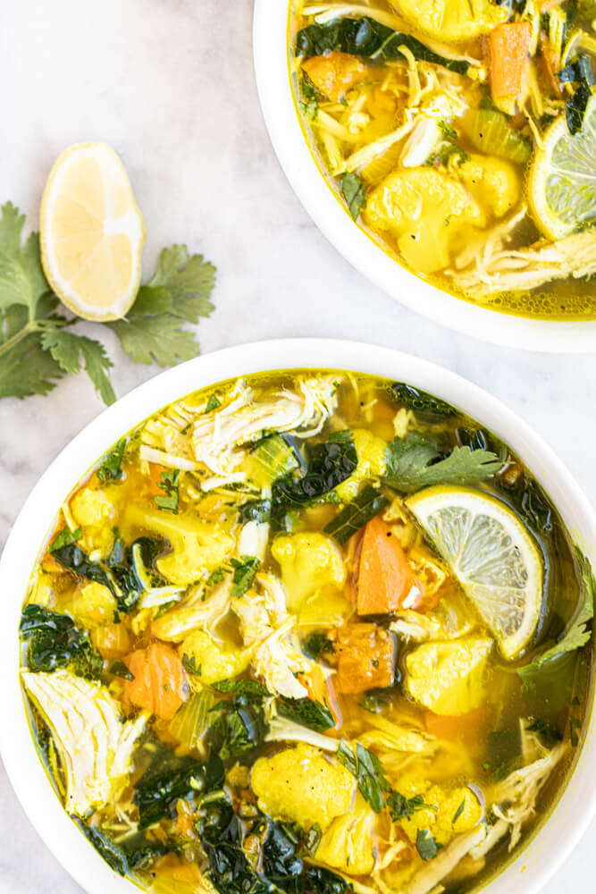 two bowls of chicken soup in white bowls