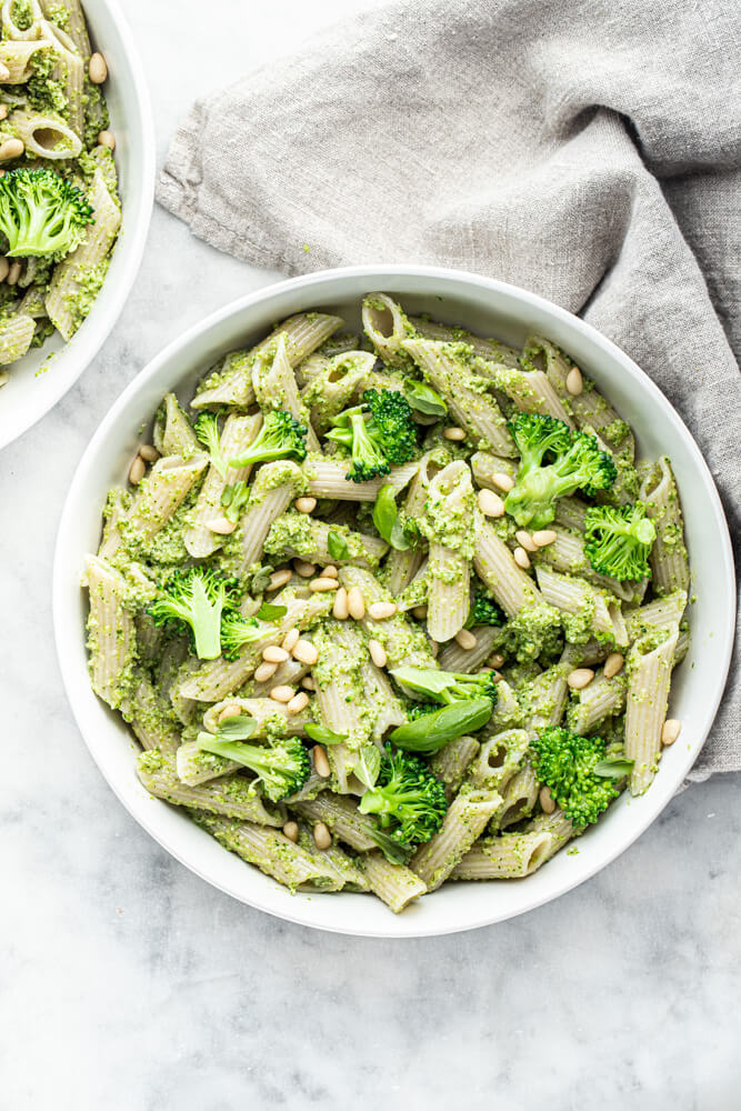 pesto pasta dish in white bowl on white counter