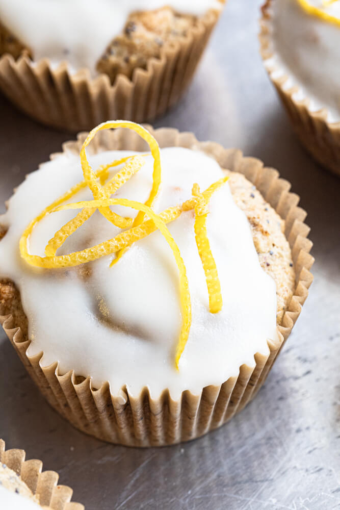 lemon poppy seed muffin with glaze and zest on top